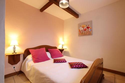 a bedroom with a bed with two pillows on it at Errekarteko-borda in Saint-Jean-le-Vieux