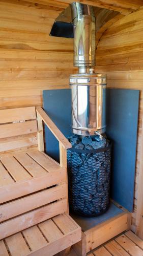 a wooden cabin with a large container of rocks at Camping Bartbo in Olsztyn