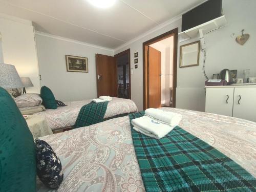 a hotel room with two beds in a room at At Whale-Phin Guest House in Reebok