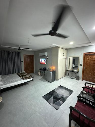 a living room with a bed and a ceiling fan at Kami House in Multan