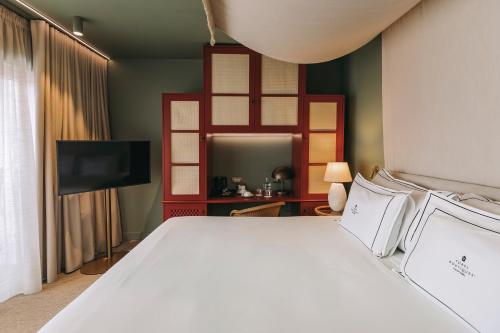 a bedroom with a white bed and a flat screen tv at Torel Terra Brava in Angra do Heroísmo