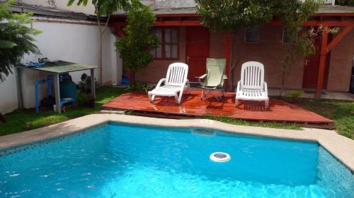 un grupo de sillas sentadas junto a una piscina en Ventana Sur Hostal en Santiago