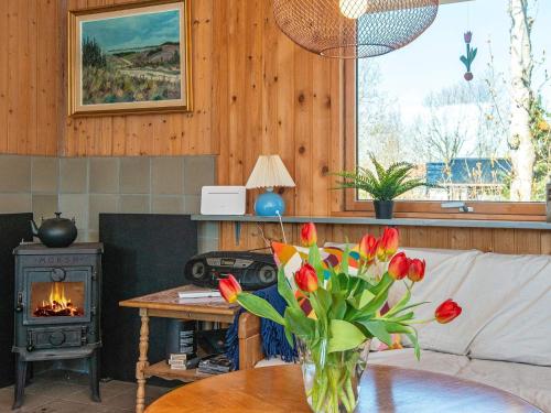 a living room with a fireplace and a vase of flowers on a table at 4 person holiday home in Allingåbro-By Traum in Allingåbro