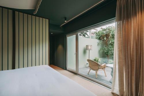a bedroom with a bed and a large window at Torel Terra Brava in Angra do Heroísmo