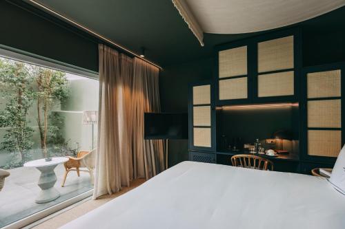 a bedroom with a white bed and a large window at Torel Terra Brava in Angra do Heroísmo
