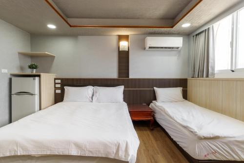 Postel nebo postele na pokoji v ubytování Love River Inn 愛河日央