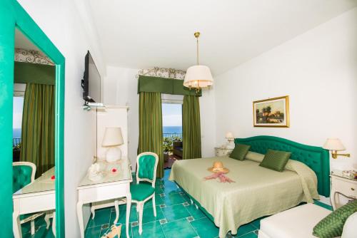 a bedroom with two beds and a table and chairs at Hotel Pellegrino in Praiano