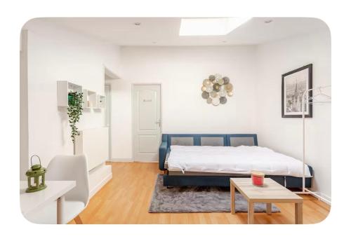 a white bedroom with a bed and a table at Maison Lumineuse à 15km de paris in Villiers-le-Bel