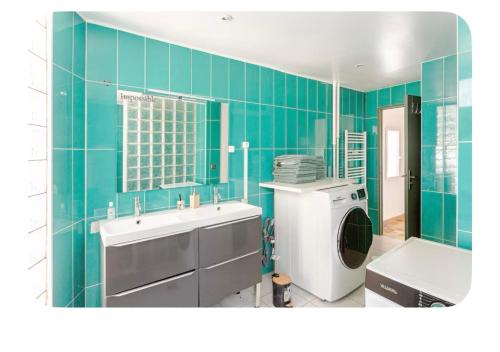 a bathroom with a sink and a washing machine at Maison Lumineuse à 15km de paris in Villiers-le-Bel