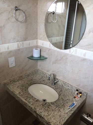 La salle de bains est pourvue d'un lavabo et d'un miroir. dans l'établissement Hotel Restaurante Boitupesca, à Boituva