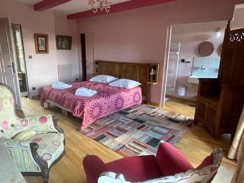 a bedroom with a bed and a couch and chairs at Le Manoir des Remparts de Besse in Besse-et-Saint-Anastaise