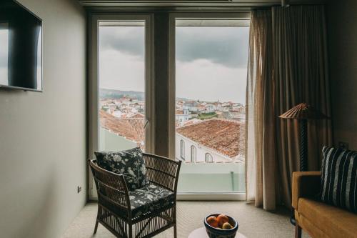 a room with a chair and a large window at Torel Terra Brava in Angra do Heroísmo