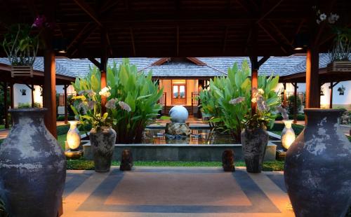 a group of vases with flowers in front of a building at Pa Sak Tong in Chiang Rai