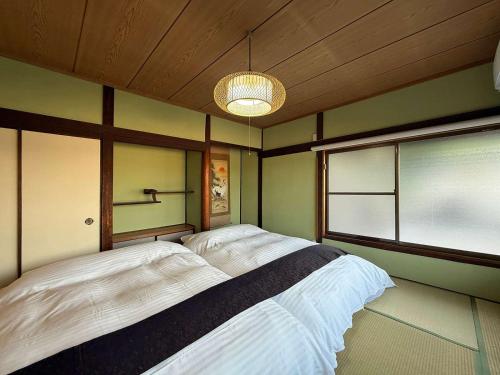 a bedroom with a large bed with a window at Ryu no Torimichi - Hilltop House Scenic Stay with City Views in Onomichi