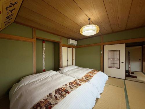 a large bed in a room with a wooden ceiling at Ryu no Torimichi - Hilltop House Scenic Stay with City Views in Onomichi