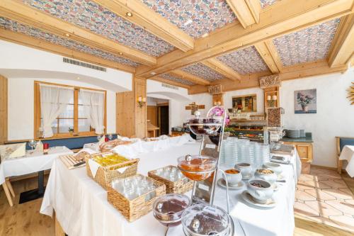 a large dining room with white tables and a wooden ceiling at Turmhotel Victoria Davos in Davos