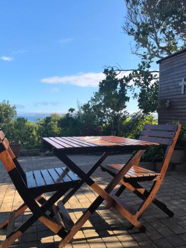 a wooden picnic table and a chair on a patio at At Whale-Phin Guest House in Reebok