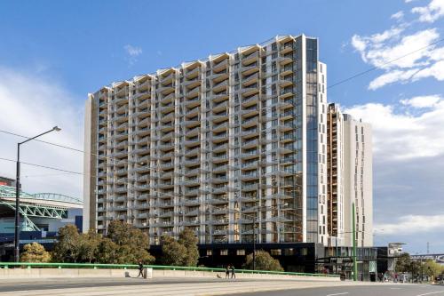 a tall building with people walking in front of it at Lovely 2 Bedroom Apt at Marvel Stadium with Car Park and Rooftop Pool in Melbourne