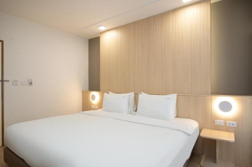 a large white bed in a room with two lights at Diya Hotel Bangkok in Amphoe Phra Khanong