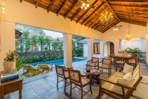 an indoor patio with tables and chairs and a pool at Villa Nea, Villas By Noor in Aldona