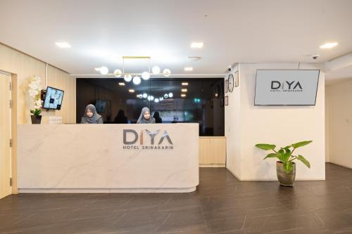 a reception area of a dermatologists office with two people at Diya Hotel Bangkok in Amphoe Phra Khanong