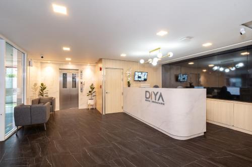 an office lobby with a davis sign on the wall at Diya Hotel Bangkok in Amphoe Phra Khanong