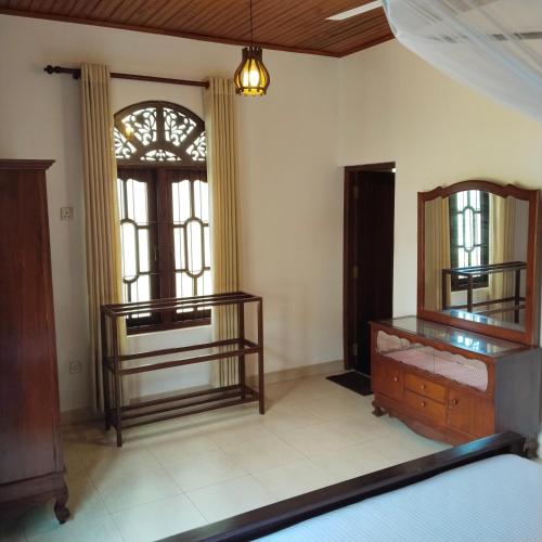 a bedroom with two bunk beds and a window at Tharul Home in Bentota