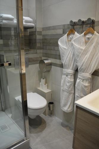 a bathroom with a toilet and a shower with towels at Appartement-terrasse parking privé Meublé de Tourisme 4 étoiles in Belfort