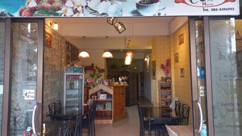 a restaurant with tables and chairs inside of a building at Amaretto Hostel in Surat Thani