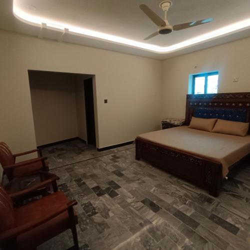 a bedroom with a bed and a chair in it at Well furnished Room in Apartment in Rahimyar Khan