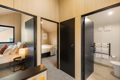 een hotelkamer met een bed en een badkamer bij Tahuna Luxury Villa Queenstown in Queenstown