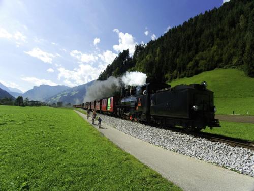 a train is traveling down the tracks near a field at Apartment in Fügen near Ski Slopes in Uderns