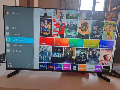 a television screen with a bunch of movies on it at Mythos Home in Mirina