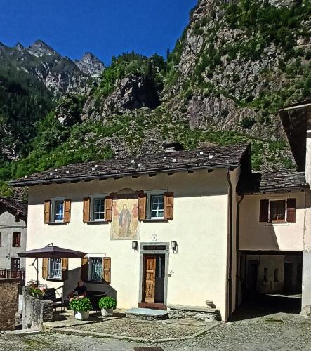 a white house with a mountain in the background at Casa Adamossi Lombardini in Alpe di Bondeno