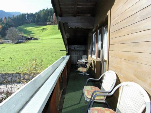 a porch of a house with two chairs and a table at Apartment in Fügen near Ski Slopes in Uderns