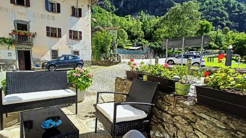 a patio with chairs and potted plants and a building at Casa Adamossi Lombardini in Alpe di Bondeno