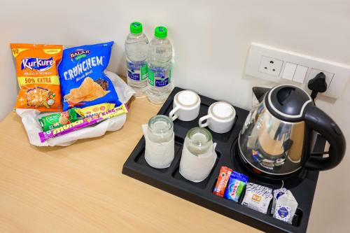a counter top with a tea kettle and some food at Hotel Konark Nest-Vijay Nagar in Indore