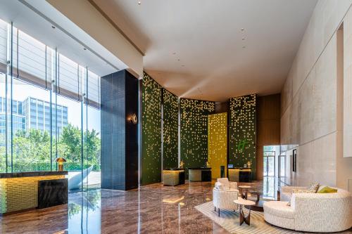 a lobby with chairs and a fireplace in a building at Holiday Inn Fuzhou Exhibition Center in Fuzhou