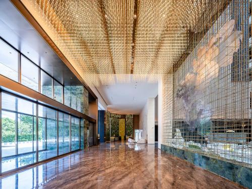 a lobby with a large wall of glass at Holiday Inn Fuzhou Exhibition Center in Fuzhou
