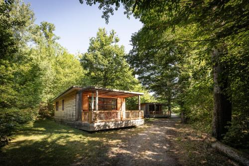 a cabin in the woods with a gravel road at Huttopia de Wattwiller in Wattwiller