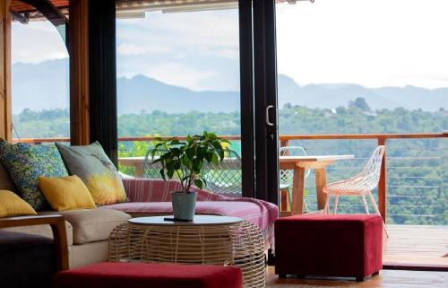 a living room with couches and a table and chairs at Loerie's Rest Cabin in Victoria Bay