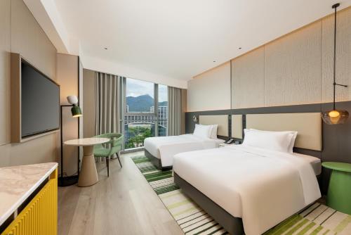a hotel room with two beds and a table at Holiday Inn Fuzhou Exhibition Center in Fuzhou