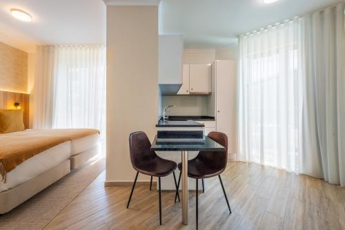 a bedroom with a bed and a table and chairs at Vila Baleira Residence in Funchal