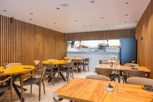 a restaurant with wooden walls and tables and chairs at Vila Baleira Residence in Funchal