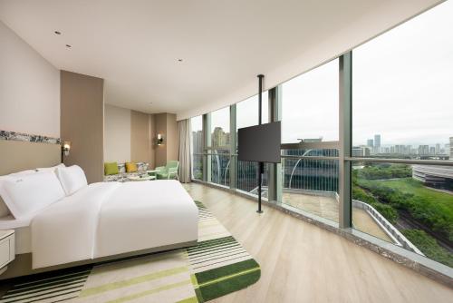 a hotel room with a bed and a large window at Holiday Inn Fuzhou Exhibition Center in Fuzhou
