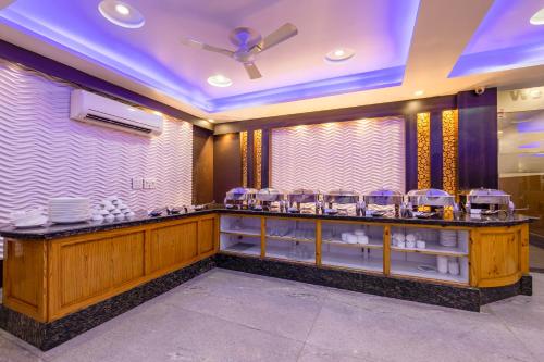 a restaurant with a counter with dishes on it at Arch Plaza - Near Yashobhoomi Convention Centre Dwarka in New Delhi