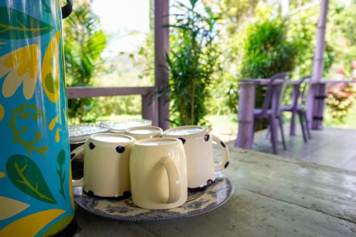a tray of coffee mugs sitting on a table at Legend Guesthouse in Kelimutu