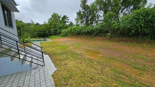 an empty yard next to a house with a fence at Nakshatra in Sawantwadi