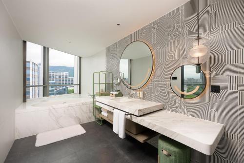 a bathroom with a sink and a tub and a mirror at Holiday Inn Fuzhou Exhibition Center in Fuzhou