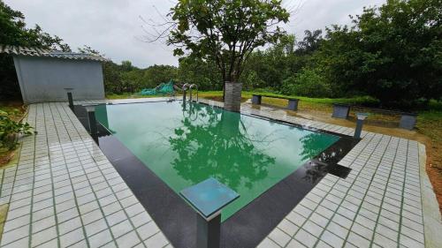 a swimming pool in the middle of a yard at Nakshatra in Sawantwadi